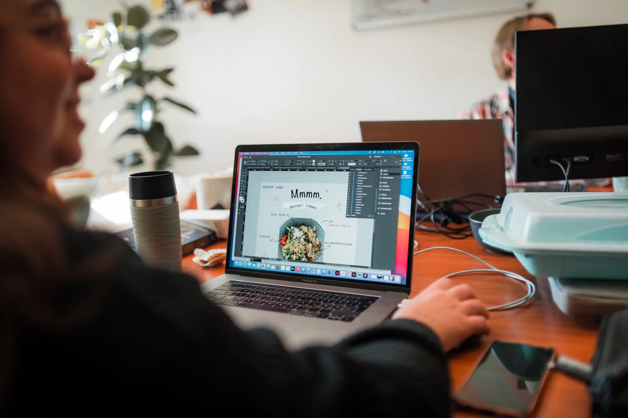 Blick über die Schulter einer sorum-Mitarbeiterin auf einen Laptop mit einem Seitenentwurf