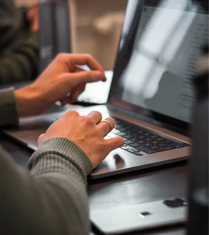 Hände auf der Tastatur eines Laptops bei der Arbeit an einer Website